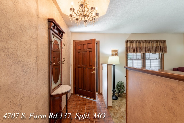 hallway with a notable chandelier and a textured ceiling