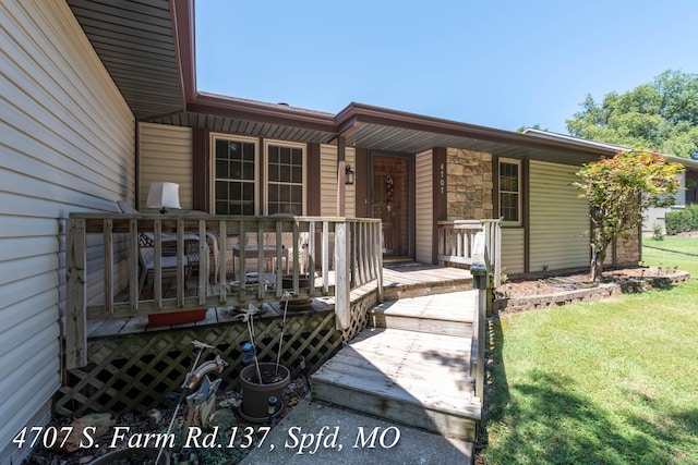 property entrance with a yard and a deck