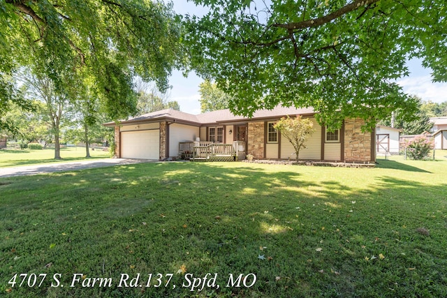 ranch-style house featuring a wooden deck, a front yard, and a garage