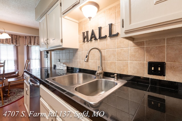 kitchen with tasteful backsplash, dishwasher, hardwood / wood-style floors, and white cabinetry