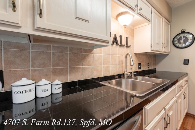 kitchen featuring white cabinets, hardwood / wood-style flooring, sink, and tasteful backsplash