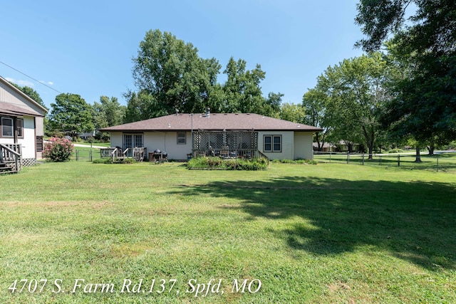 back of house featuring a lawn