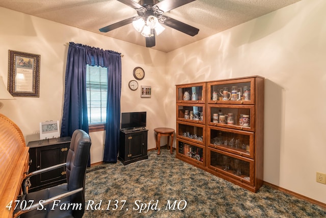 office area featuring ceiling fan, dark carpet, and a textured ceiling