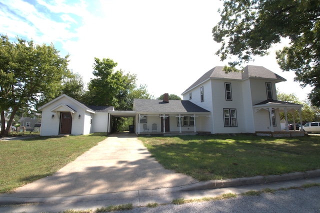 view of front of house with a porch, a carport, and a front lawn