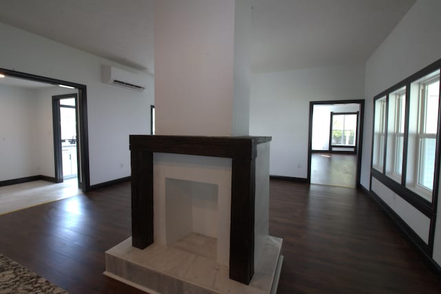 interior space with dark wood-type flooring and a wall mounted air conditioner