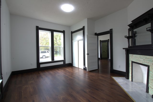 327 E Chestnut St, Bolivar, MO 65613 - unfurnished living room featuring a fireplace with flush hearth, baseboards, dark wood-style flooring, and a barn door