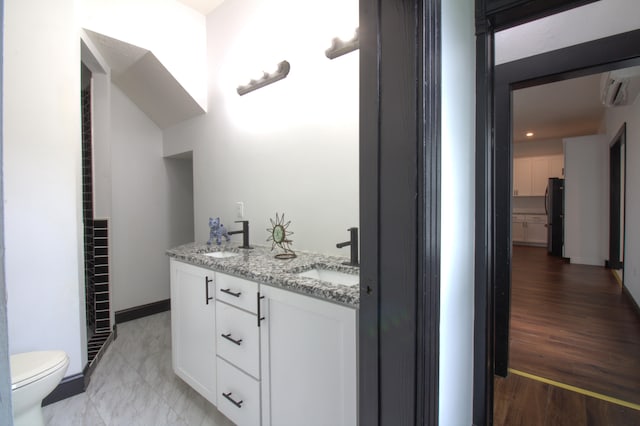 bathroom with wood-type flooring, a wall mounted AC, vanity, and toilet