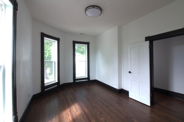 unfurnished room featuring a barn door and dark hardwood / wood-style floors