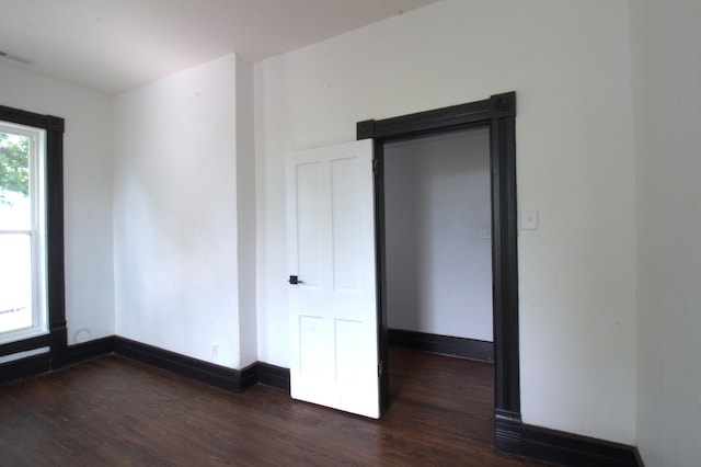 unfurnished room with dark hardwood / wood-style flooring