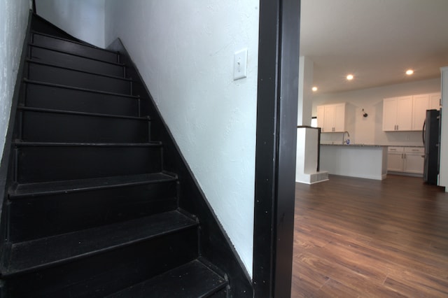 stairway with hardwood / wood-style flooring and sink