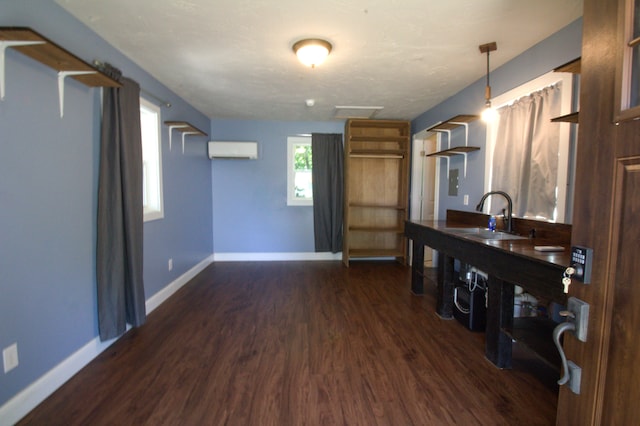 interior space featuring sink, dark hardwood / wood-style flooring, and a wall unit AC