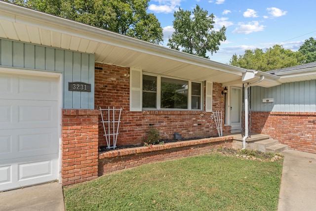 entrance to property with a garage and a lawn