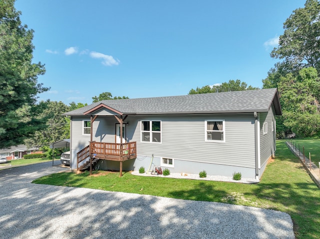 view of front of home featuring a front lawn and a deck