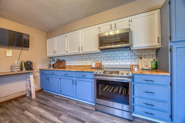 kitchen featuring dark wood finished floors, blue cabinetry, tasteful backsplash, a textured ceiling, and appliances with stainless steel finishes