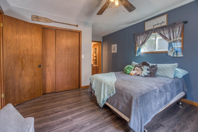 bedroom with a closet, dark hardwood / wood-style floors, a textured ceiling, and ceiling fan