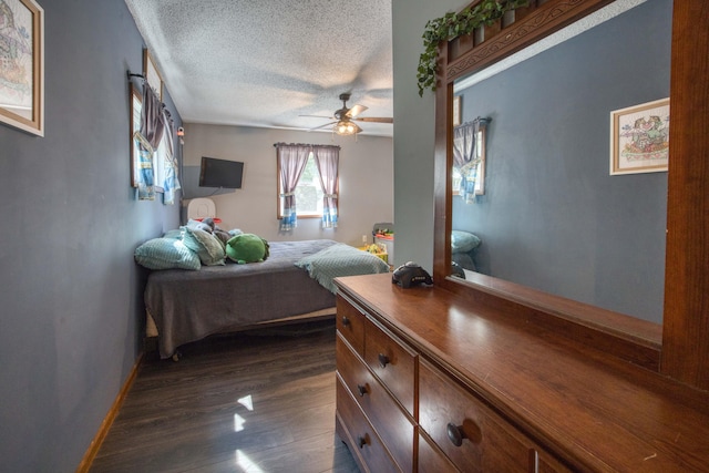 bedroom with dark wood-type flooring, a textured ceiling, baseboards, and ceiling fan