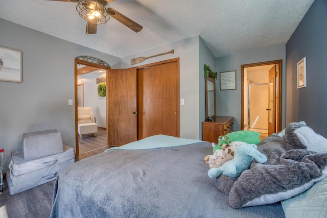 bedroom featuring wood finished floors, a ceiling fan, connected bathroom, a closet, and a textured ceiling
