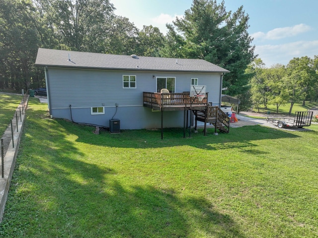 back of house featuring an outdoor fire pit, a lawn, and a deck