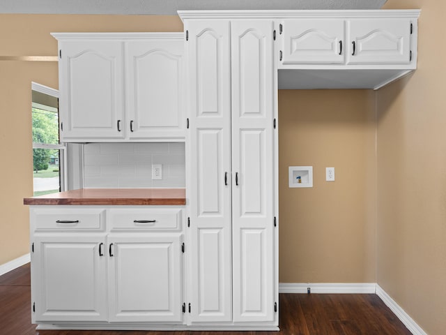 kitchen with dark hardwood / wood-style flooring, backsplash, and white cabinets