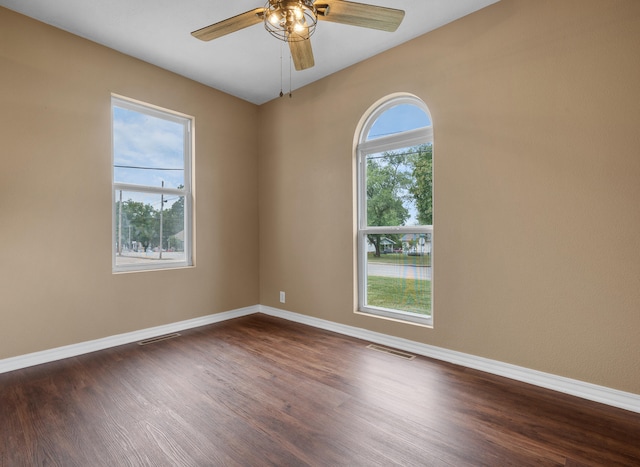 702 E Buffalo St, Bolivar, MO 65613 - spare room featuring dark wood finished floors, visible vents, a ceiling fan, and baseboards