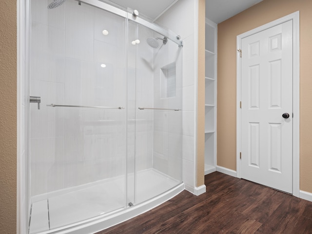 bathroom featuring wood-type flooring and a shower with shower door