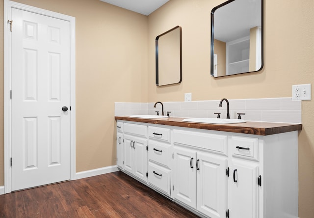 bathroom with hardwood / wood-style flooring, vanity, and backsplash