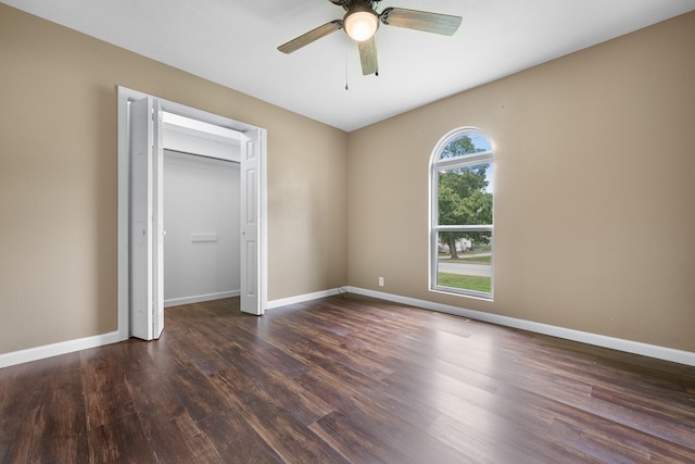 unfurnished bedroom featuring a closet, dark hardwood / wood-style flooring, and ceiling fan