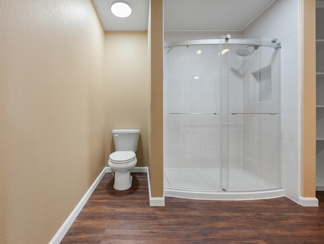 bathroom featuring walk in shower, wood-type flooring, and toilet