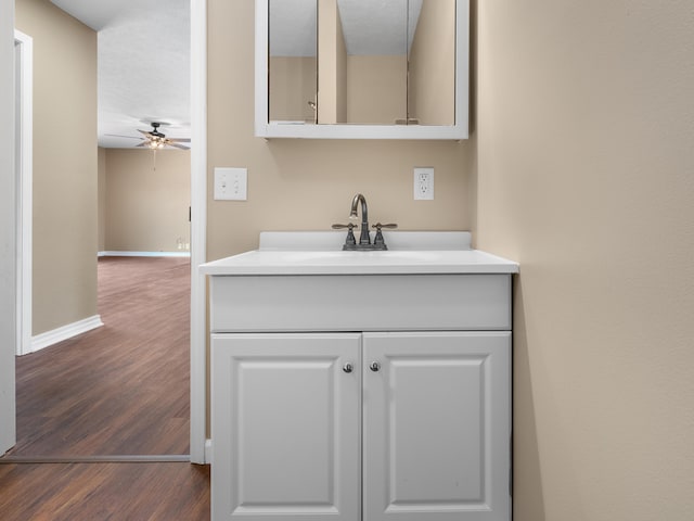 702 E Buffalo St, Bolivar, MO 65613 - bathroom with baseboards, wood finished floors, vanity, and ceiling fan