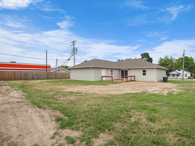 back of property featuring a wooden deck and a lawn