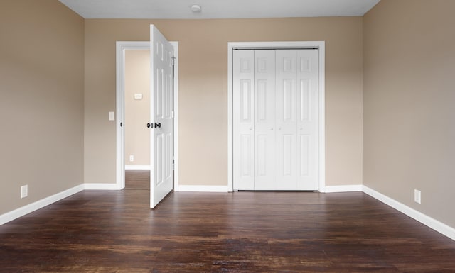 unfurnished bedroom featuring a closet and dark hardwood / wood-style floors