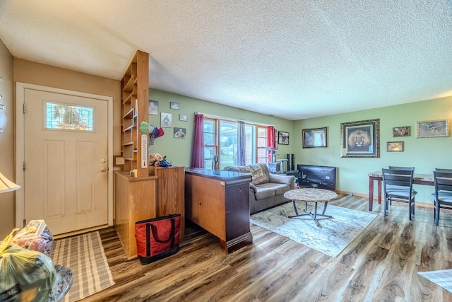 living room with a textured ceiling and dark hardwood / wood-style floors