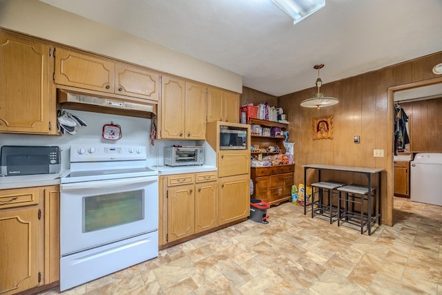 kitchen with wood walls, washer / dryer, electric stove, and hanging light fixtures