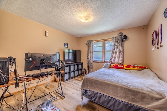 bedroom with wood-type flooring and a textured ceiling