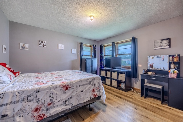 bedroom with a textured ceiling and light hardwood / wood-style flooring