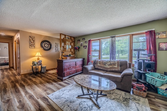 living room with dark wood-type flooring, a healthy amount of sunlight, and a textured ceiling