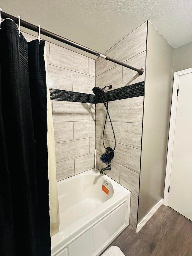 bathroom featuring a textured ceiling, shower / tub combo, and hardwood / wood-style floors