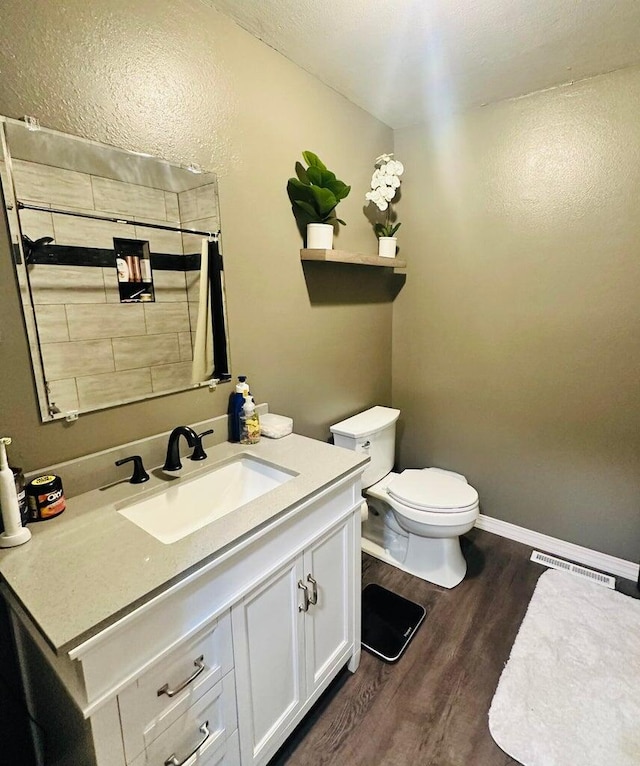 bathroom featuring wood-type flooring, a shower with shower curtain, vanity, and toilet