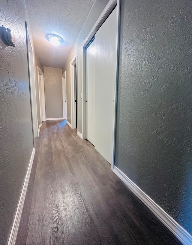 hall featuring hardwood / wood-style floors and a textured ceiling