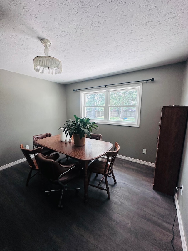 dining space with dark hardwood / wood-style flooring and a textured ceiling