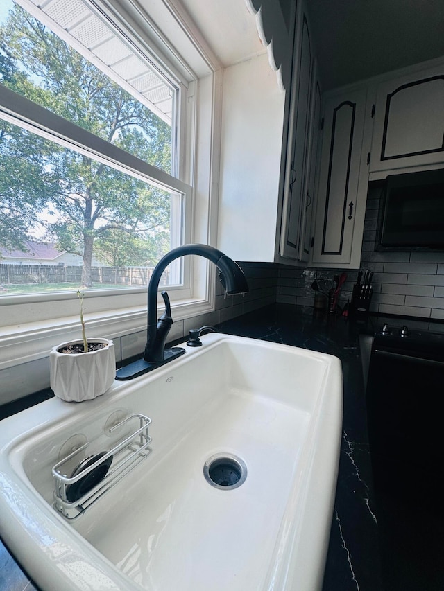 room details with backsplash, sink, and gray cabinetry