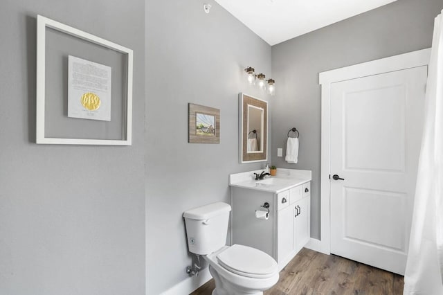 bathroom with wood-type flooring, vanity, and toilet