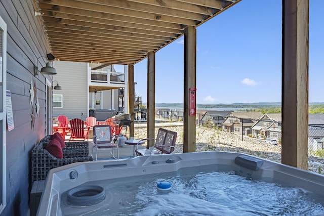 view of patio / terrace with a balcony and a hot tub