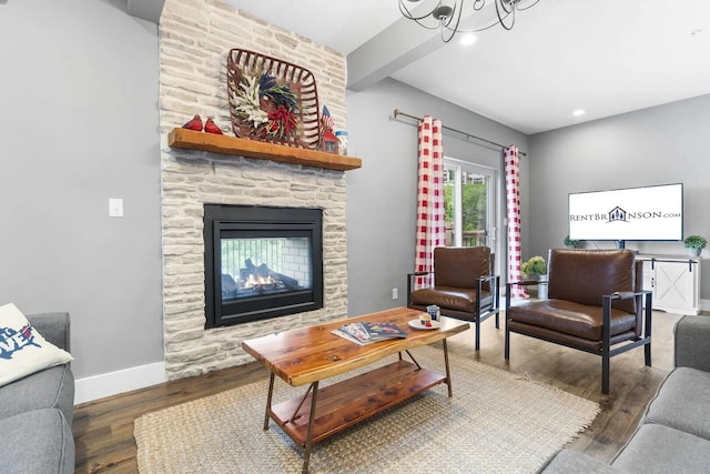 living room featuring a fireplace, a notable chandelier, and dark hardwood / wood-style flooring