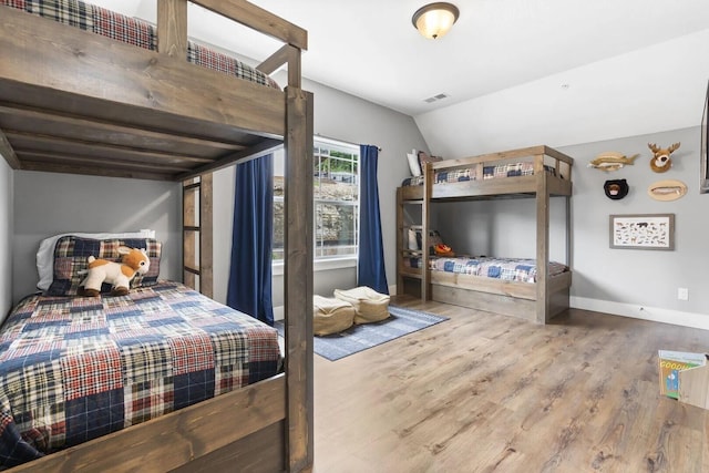 bedroom with wood-type flooring and lofted ceiling