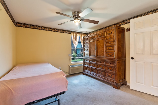 carpeted bedroom with a wall unit AC and ceiling fan