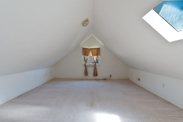 bonus room with light colored carpet and lofted ceiling with skylight