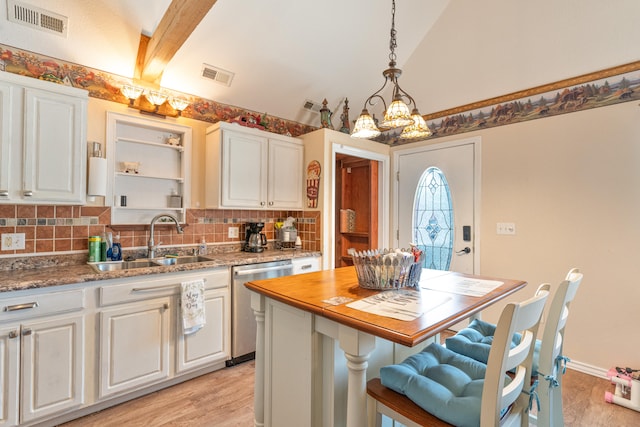 kitchen featuring pendant lighting, stainless steel dishwasher, sink, and white cabinetry