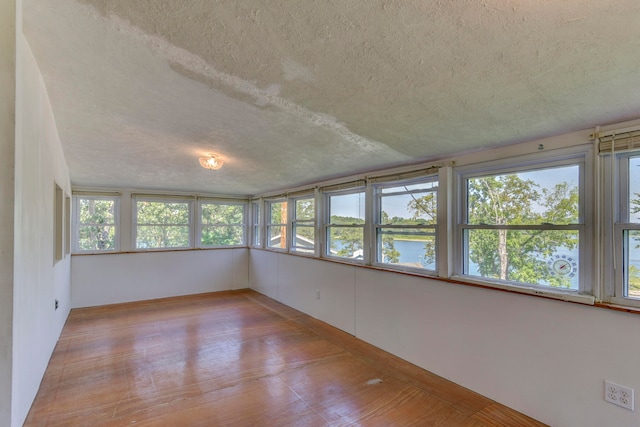 unfurnished sunroom featuring a water view