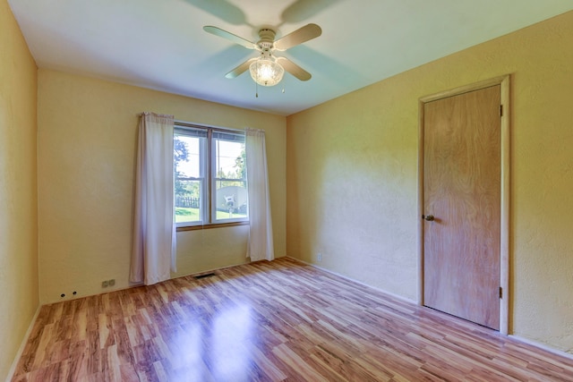 empty room with light hardwood / wood-style floors and ceiling fan